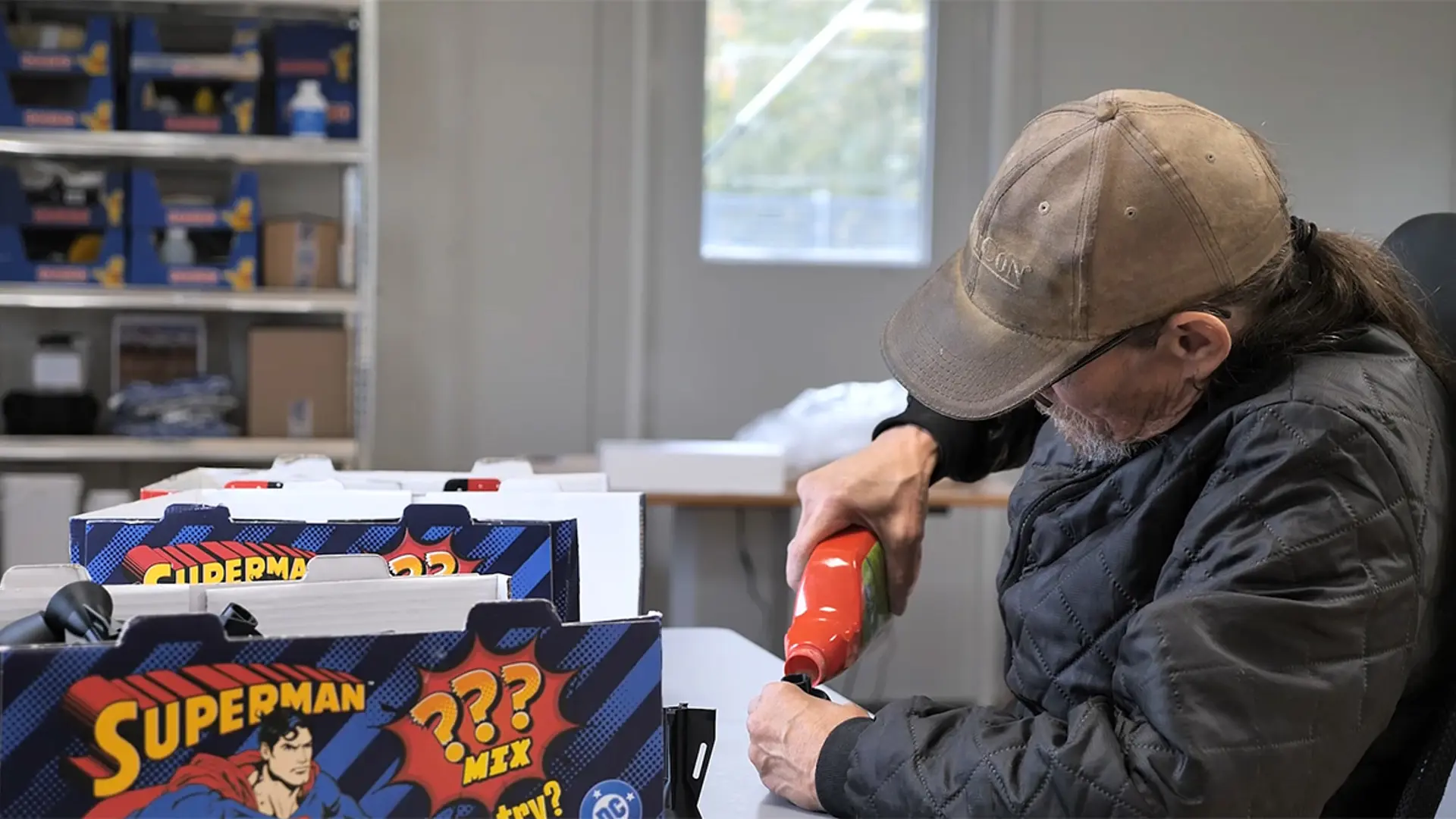 Mand med kasket arbejder ved bord