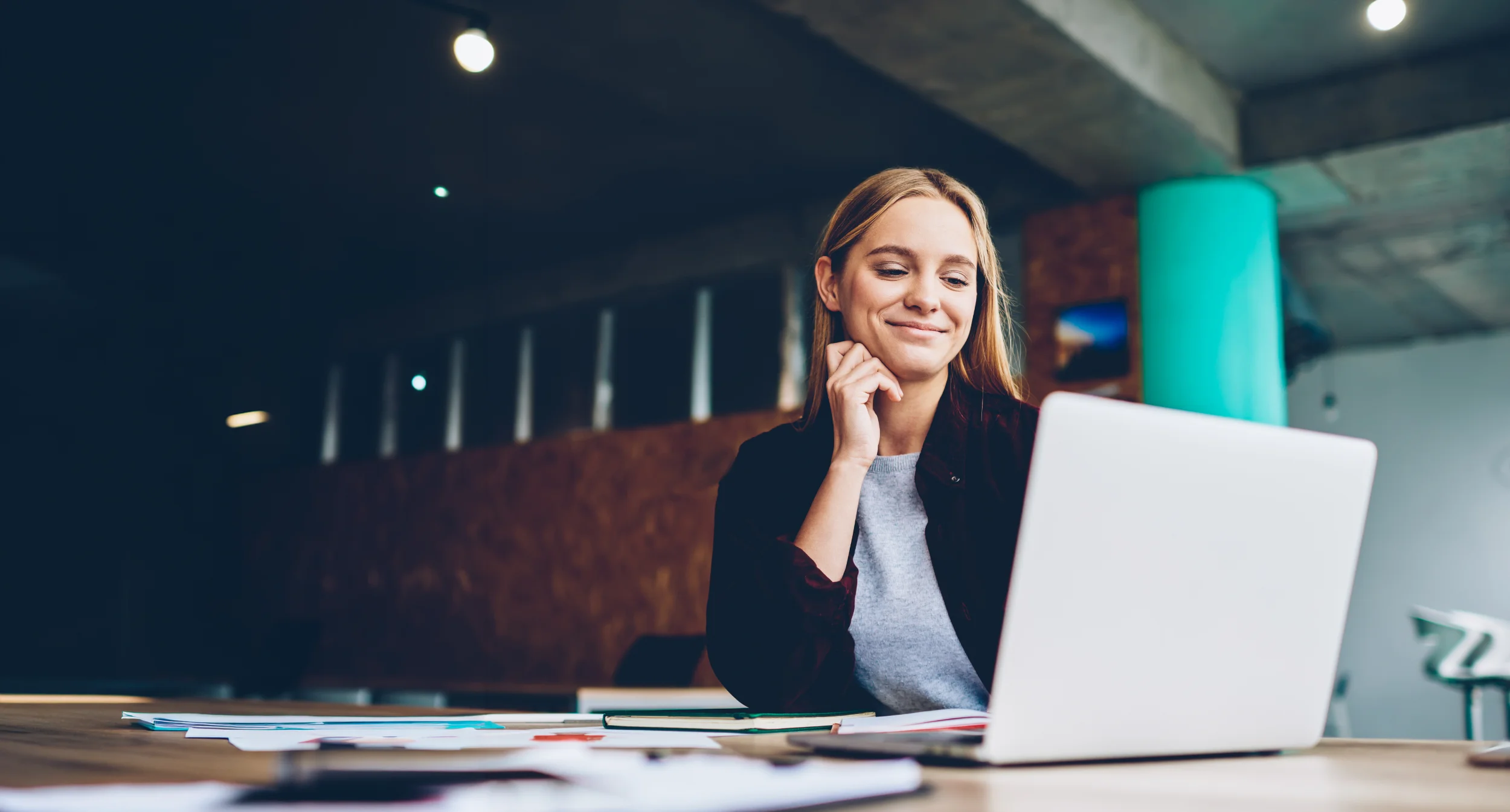 Kvinde smiler foran computer