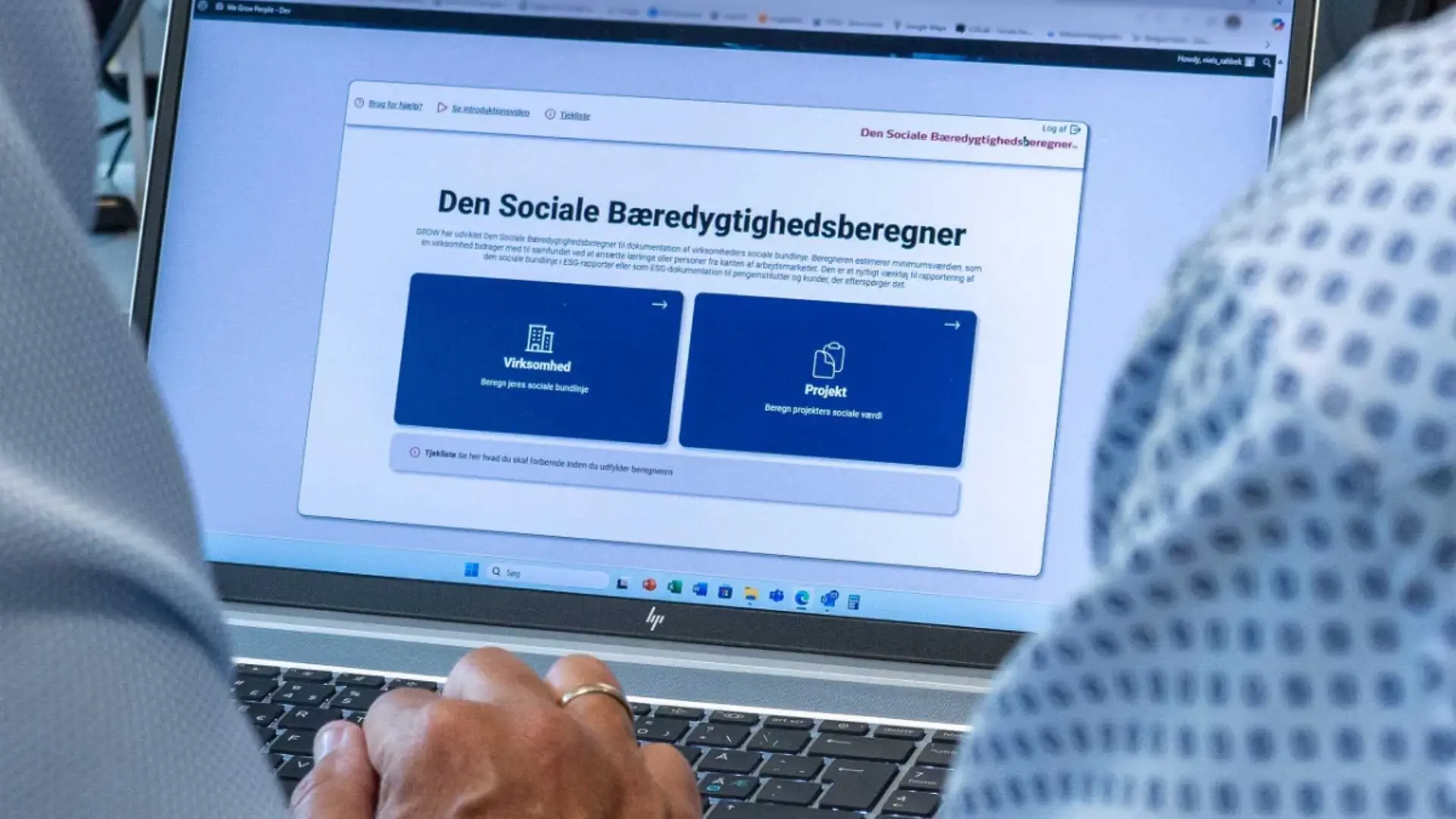 PC med skærmbillede af Den Sociale Bæredygtighedsberegner